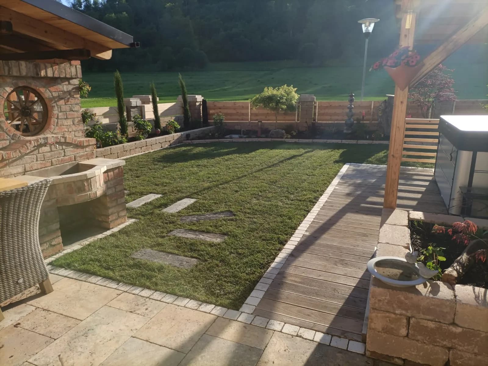 Angelegter Garten mit Terrasse, Natursteinmauer und Rasenfläche