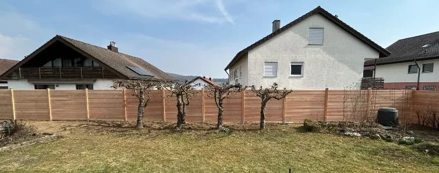 Gesetzter Holzzaun mit Spalier entlang der Grundstücksgrenze